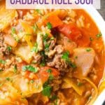Bowl of unstuffed cabbage roll soup in front of Dutch oven
