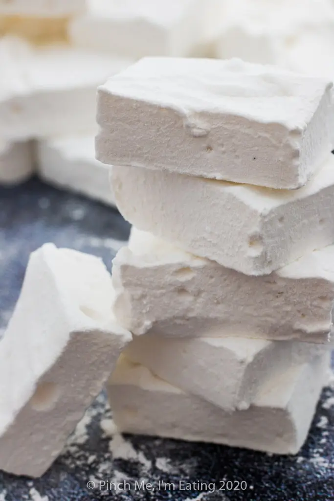 A homemade marshmallow leans against a stack of five marshmallows.