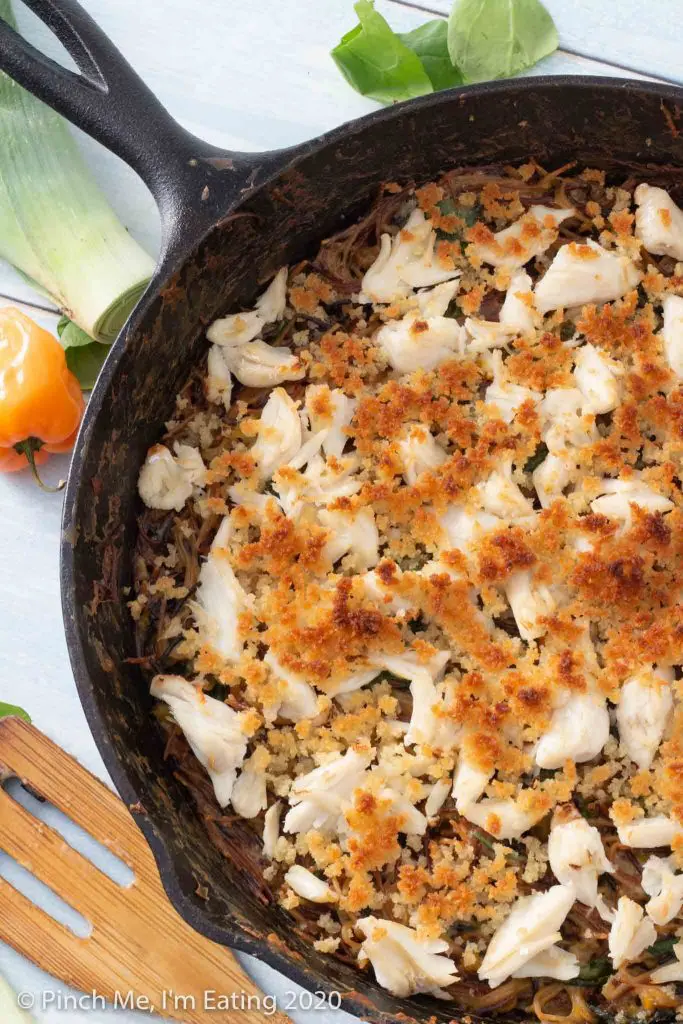 Overhead view of toasted angel hair pasta with crab and preserved lemon in a cast iron skillet with browned bread crumbs on top