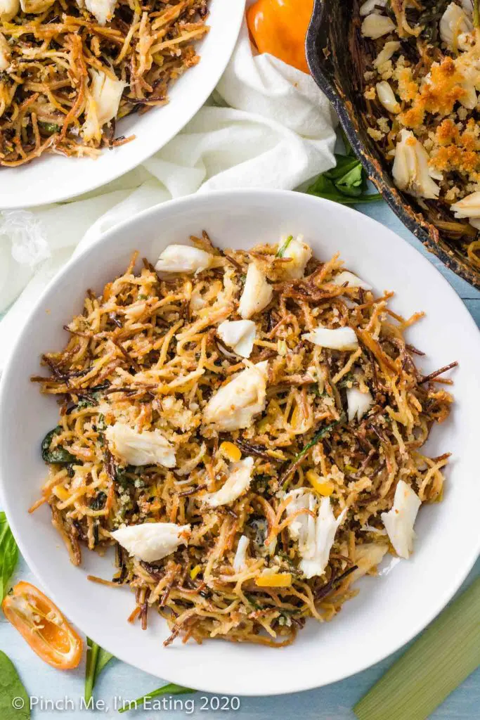 Overhead view of toasted angel hair pasta with crab and preserved lemon in a white bowl