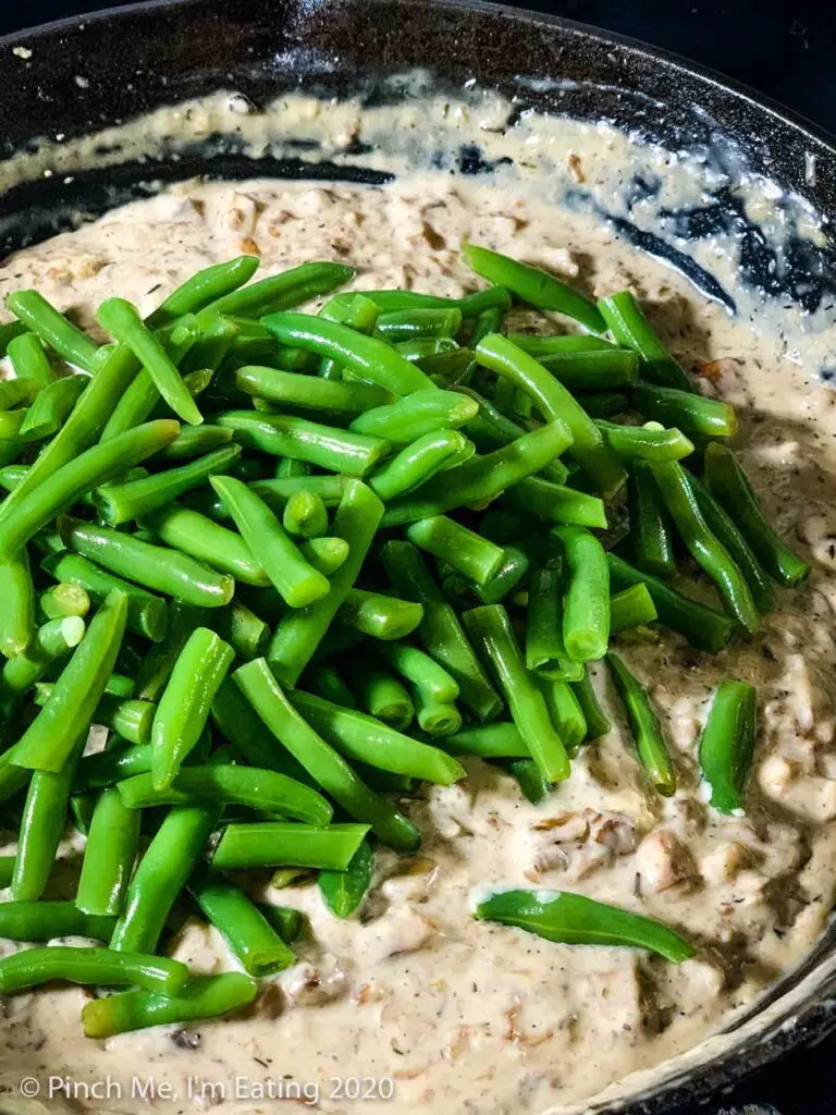 Fresh green beans in a pan of homemade cream of mushroom soup