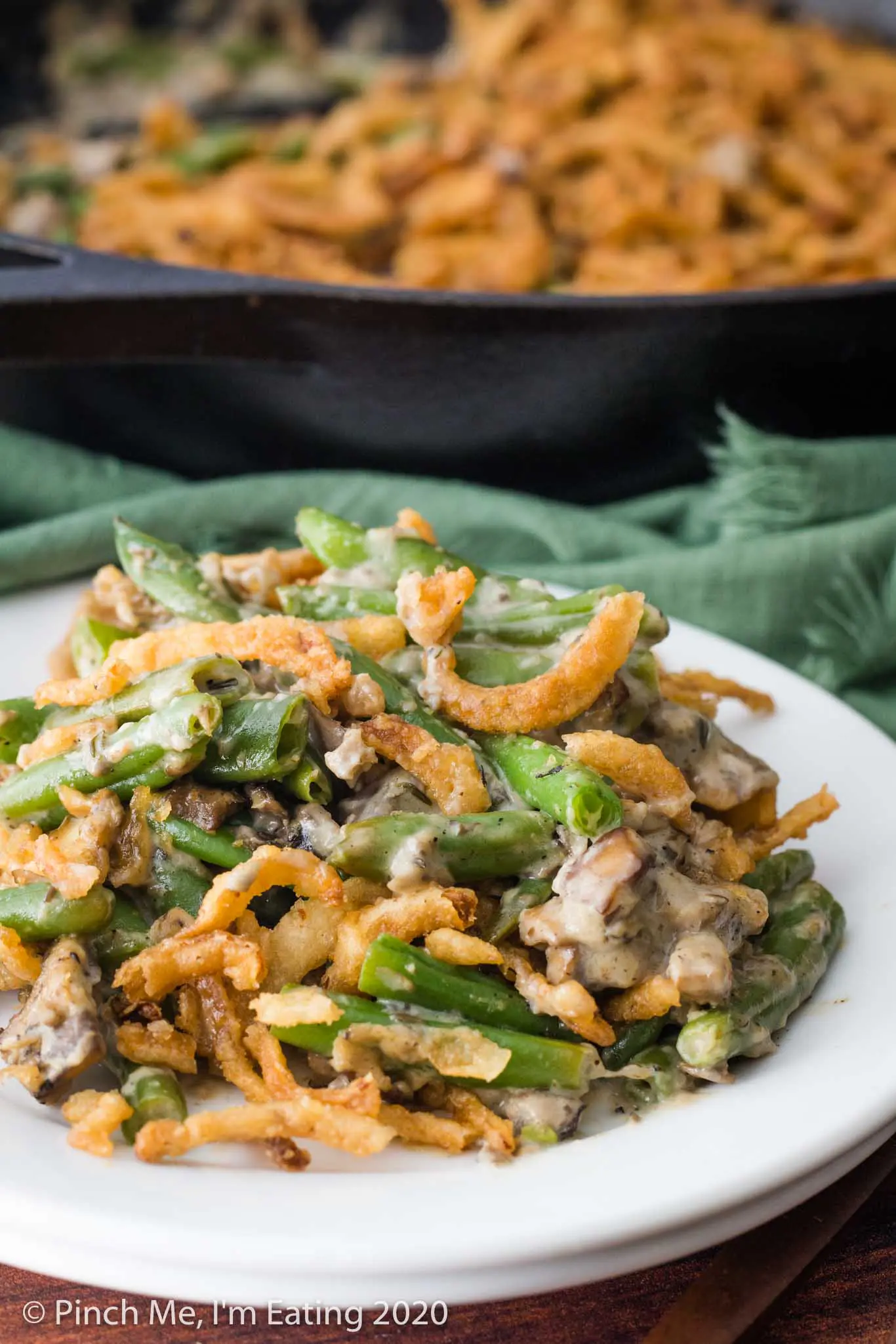 A serving of fresh green bean casserole on a small white plate