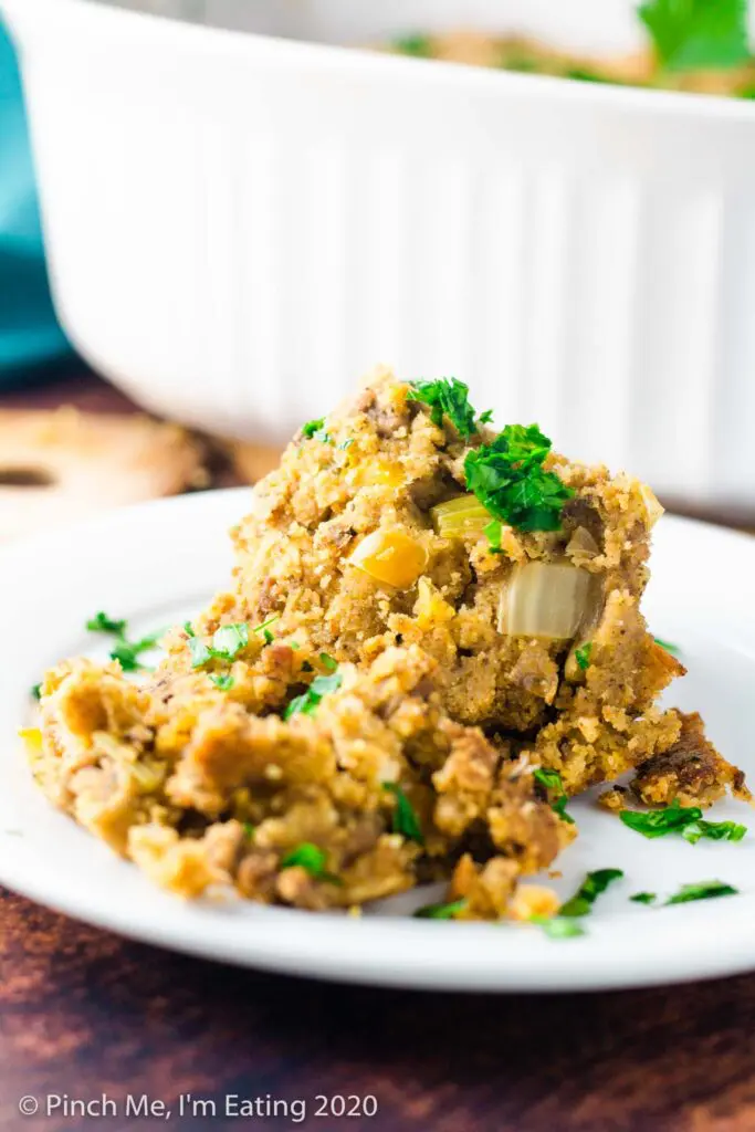 Side view of a serving of Southern cornbread dressing on a small white plate