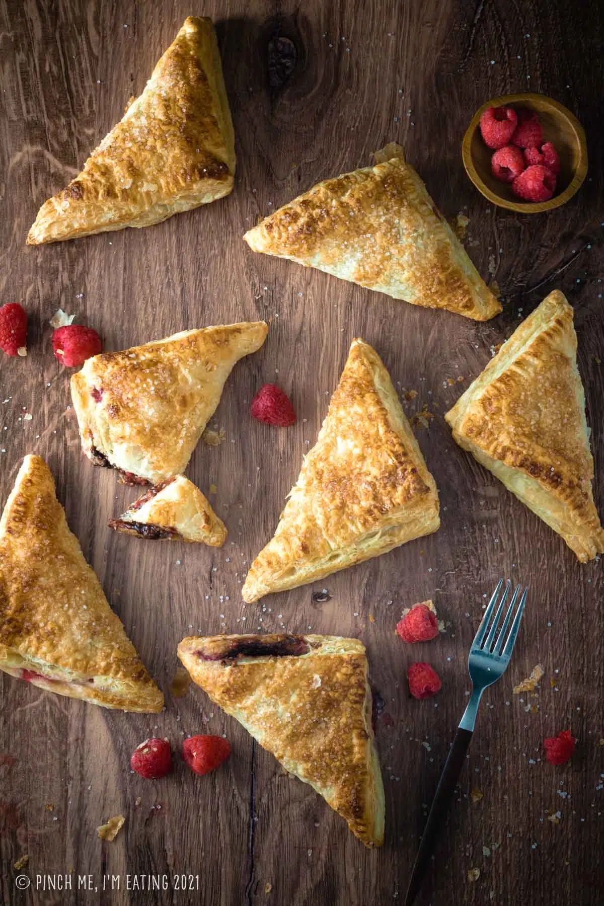 Overhead shot of raspberry Nutella turnovers on a dark background.
