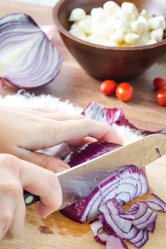 Cutting red onion into one-inch slivers.