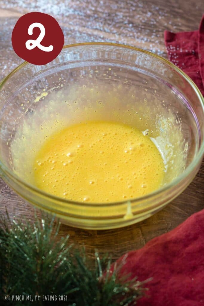 Lightly whisked egg yolks in a clear bowl.