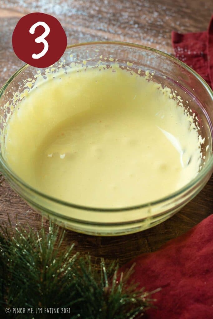 Egg yolks in a clear bowl whisked until thick and light colored.
