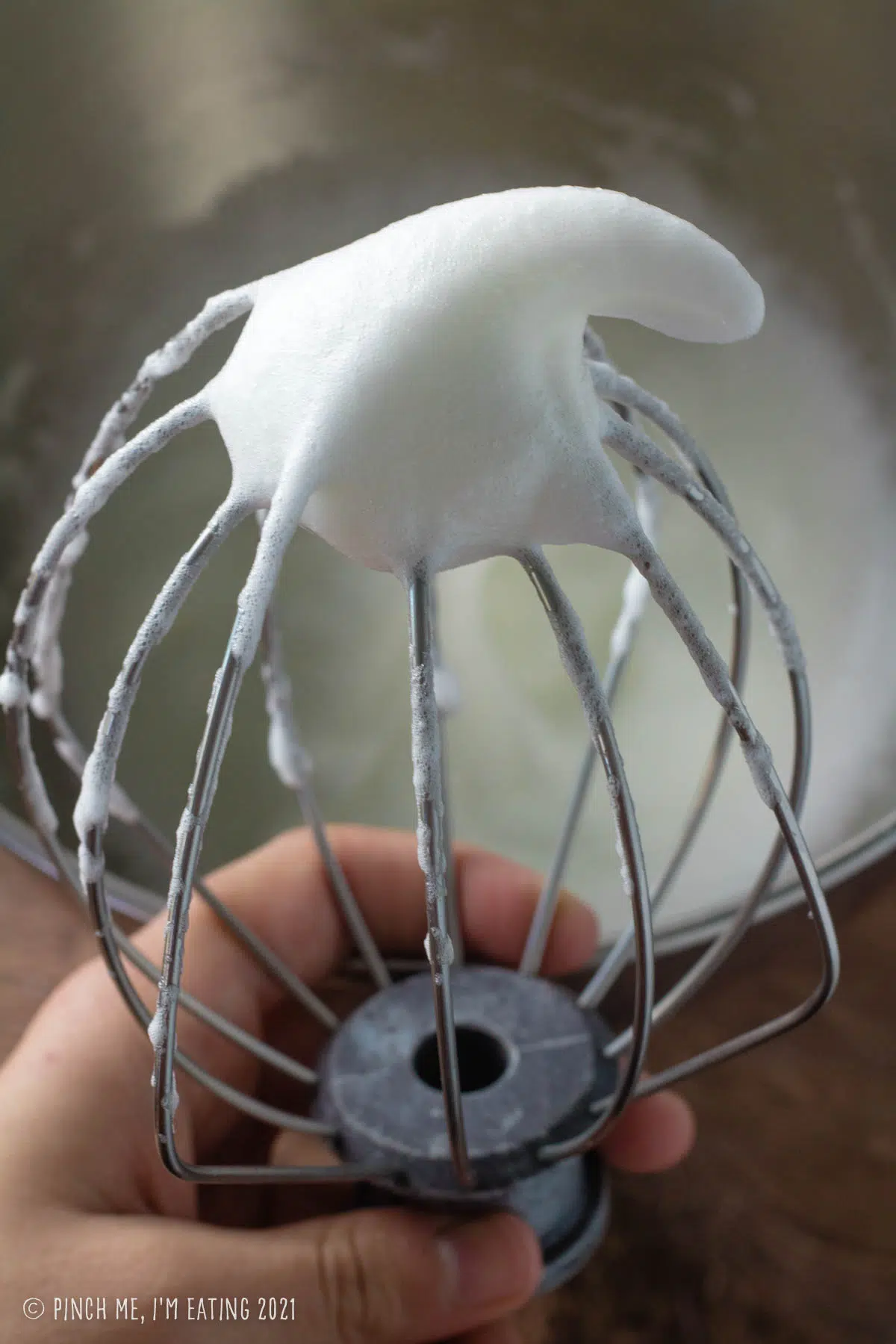 Egg whites whipped to stiff peaks on a whisk.