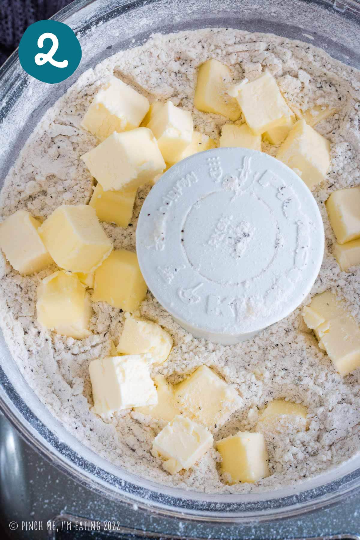 Cold butter cubes in a food processor with dry ingredients for earl grey scones.