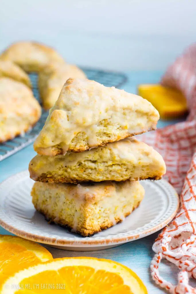 Glazed orange scones on white plate.