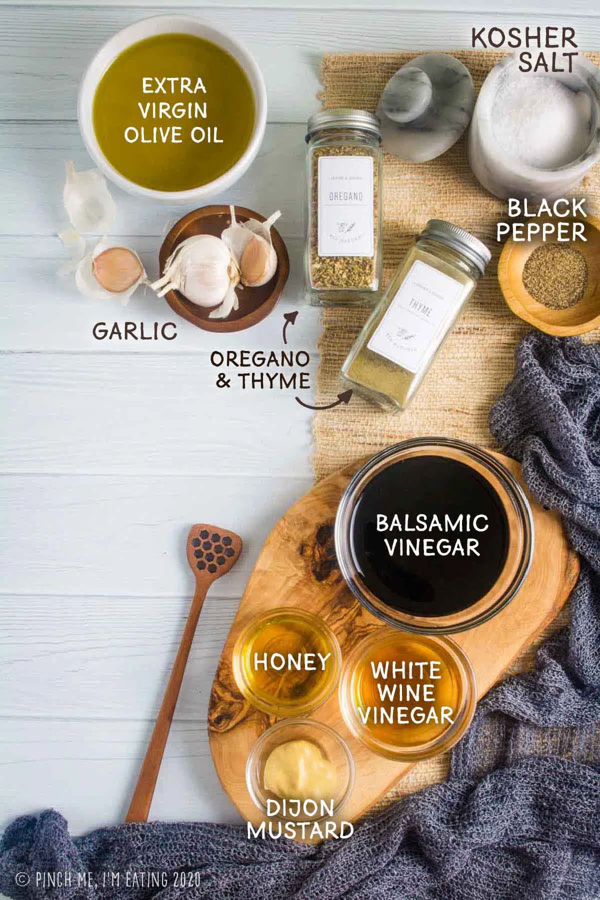 Ingredients for homemade creamy balsamic dressing with honey, dijon mustard, garlic, and olive oil.