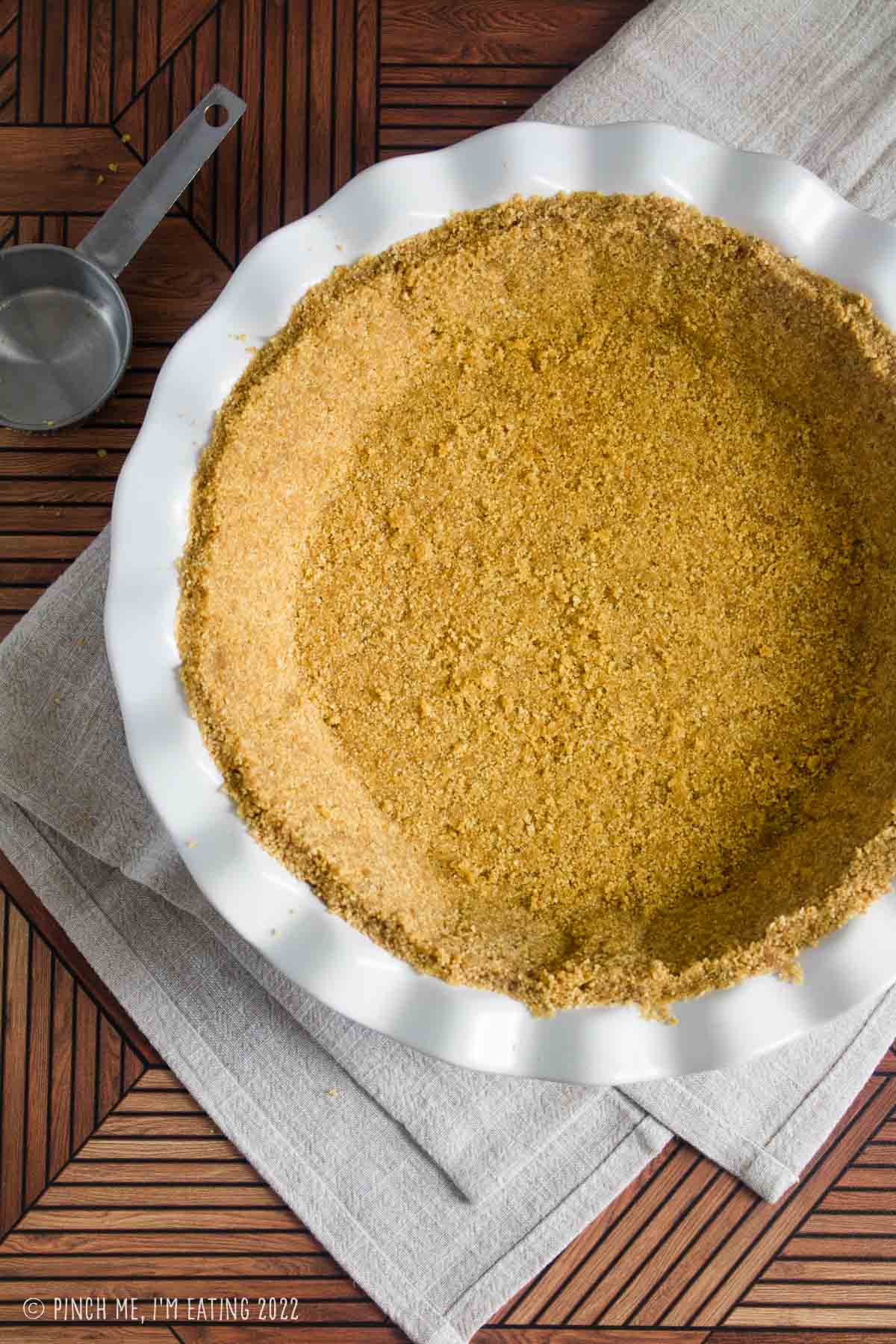 No-bake graham cracker crust in a white ceramic pie plate.