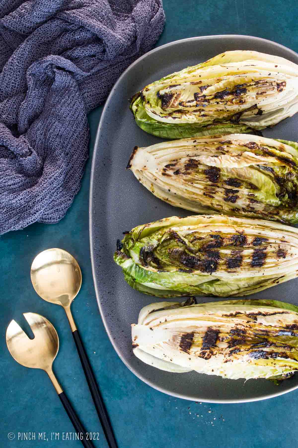 Grilled romaine hearts on a gray platter.