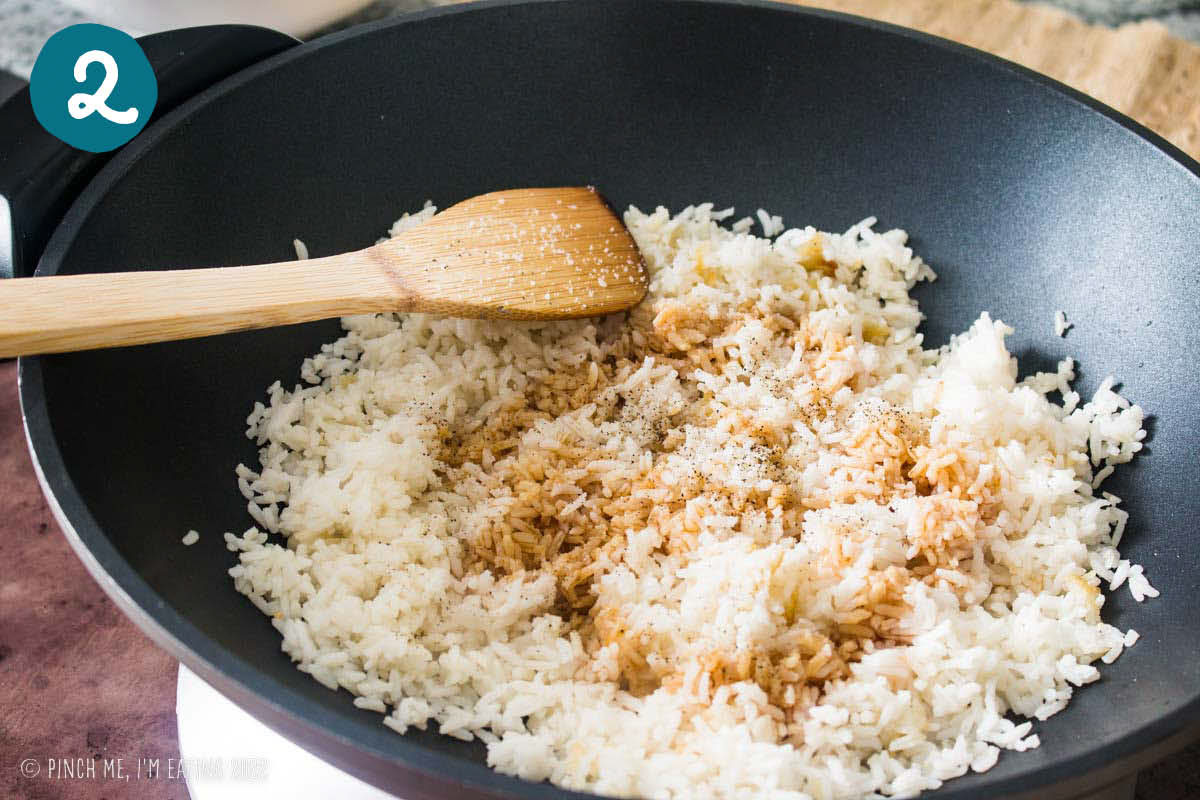 White rice drizzled with soy sauce in a wok.