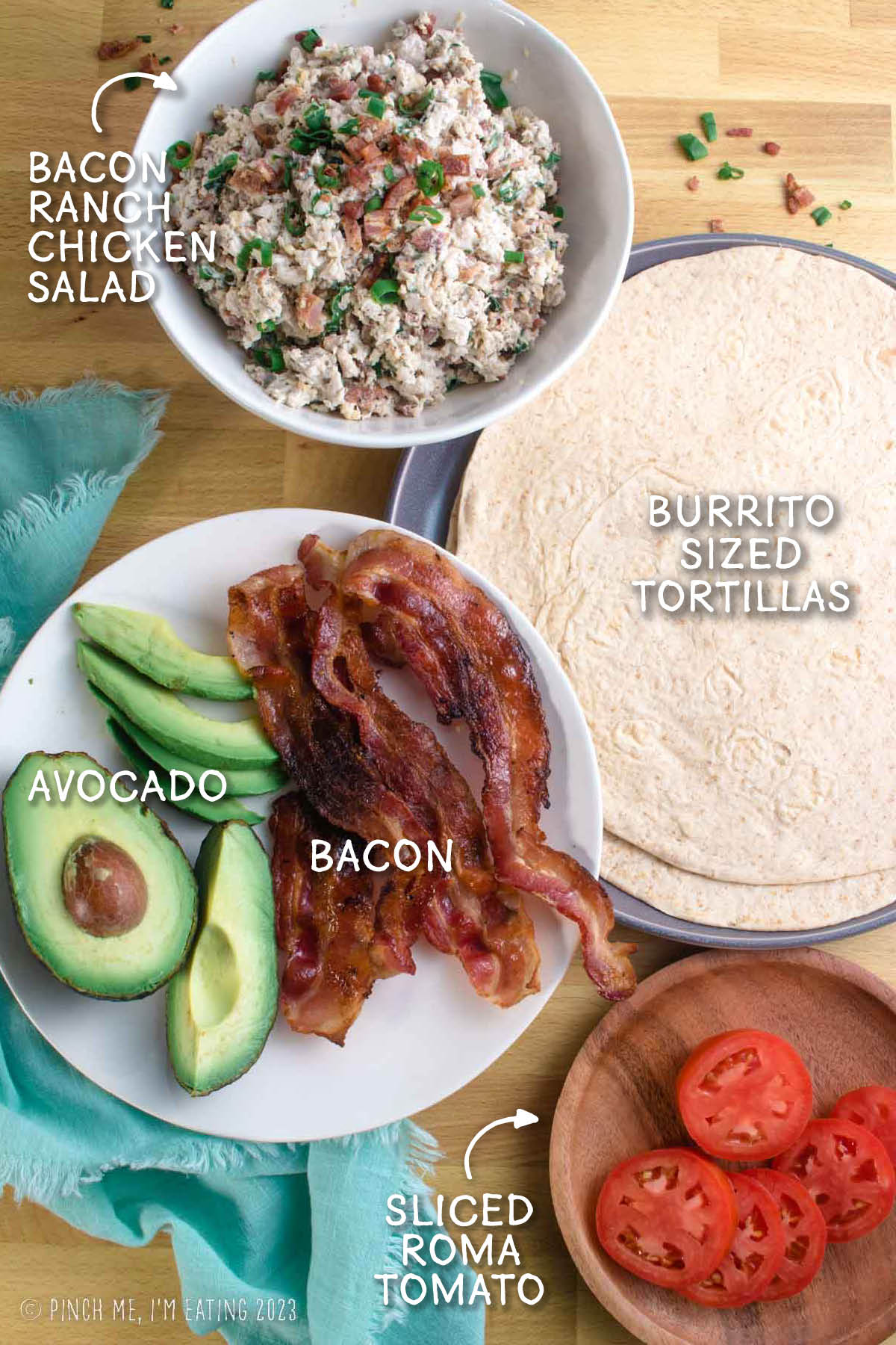 Ingredients for a bacon ranch chicken salad wrap with tomato and avocado.