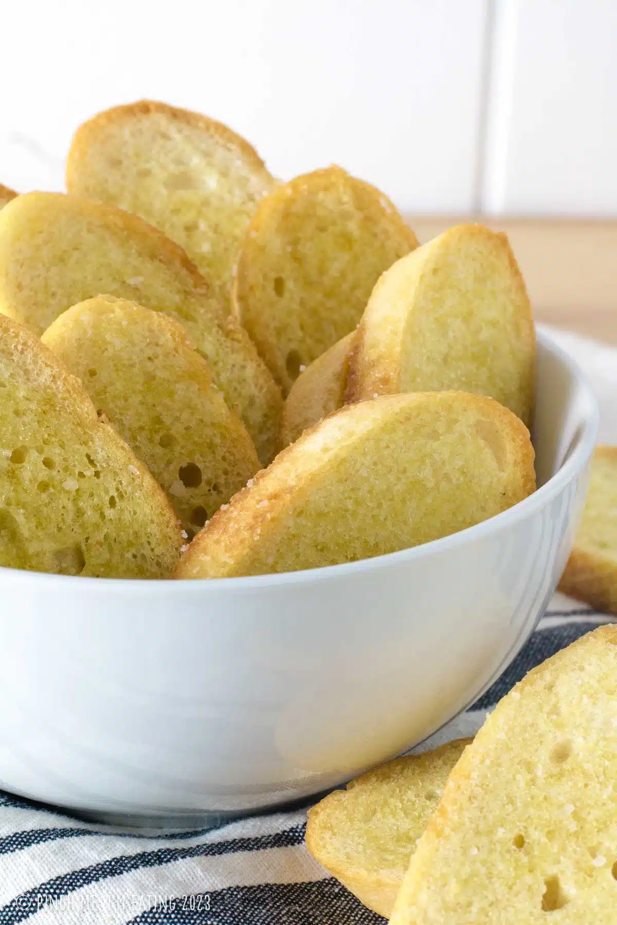 Crostini slices in a white bowl.