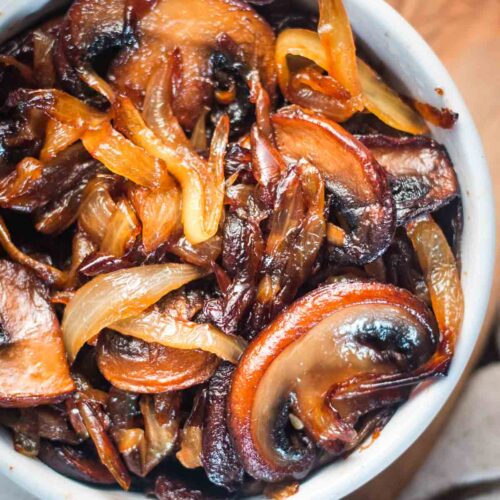 Caramelized onions and mushrooms in a small white bowl.