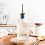 Simple syrup in a glass bottle with a gold spout.