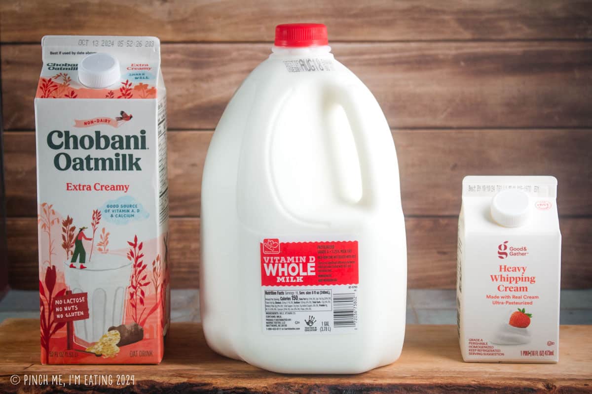 Cartons of oat milk, whole dairy milk, and heavy cream.
