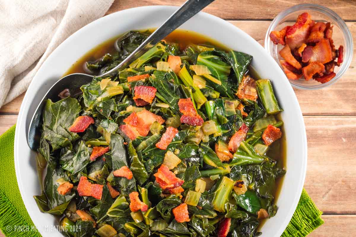 Cooked greens with bacon in a white bowl.