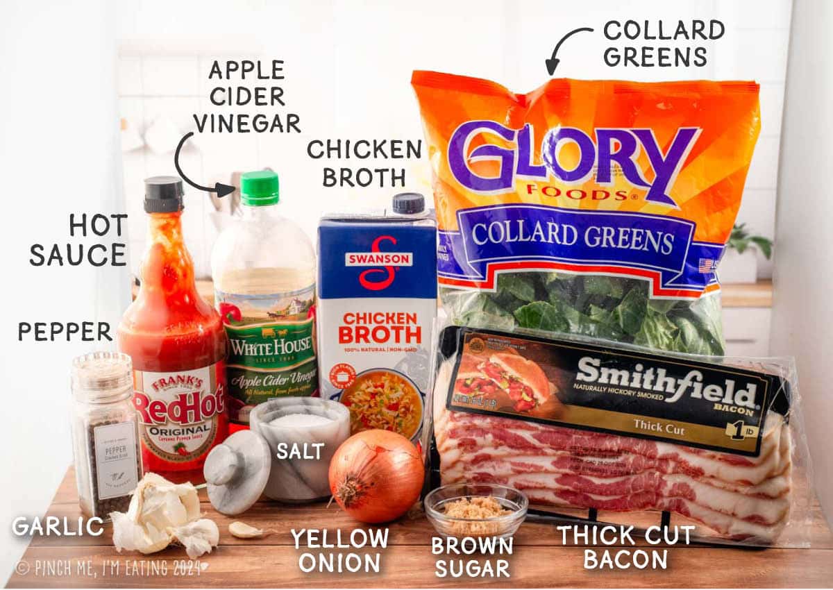 Ingredients to make collard greens, including chicken broth, bacon, vinegar, hot sauce, onion, brown sugar, garlic, salt, and pepper.