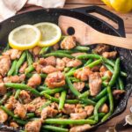 Chicken and green beans in a cast iron skillet.