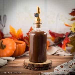 Pumpkin spice sauce for coffee in a glass bottle with a pour spout.