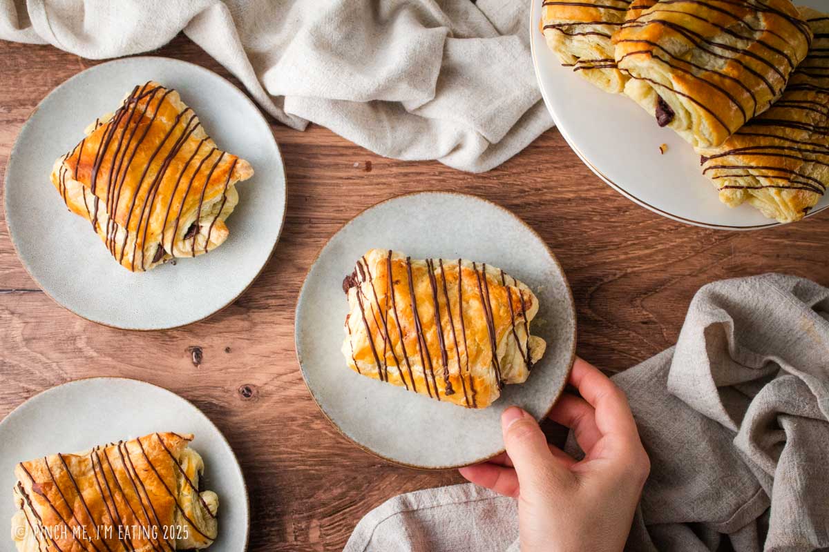 Chocolate croissants on small plates.
