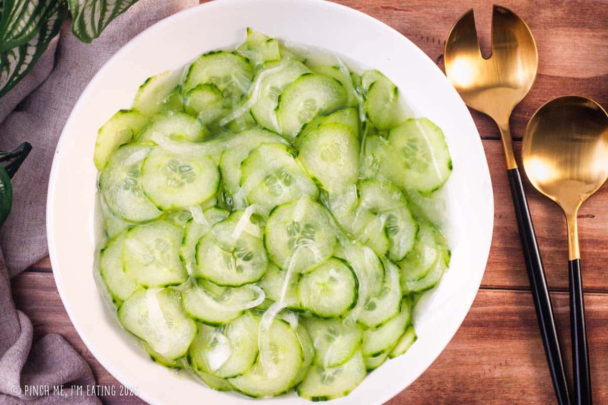 Cucumber onion salad in a white bowl.