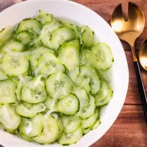 Cucumber salad in a white bowl.