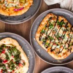 Multiple personal sized pizzas for a build your own pizza party.