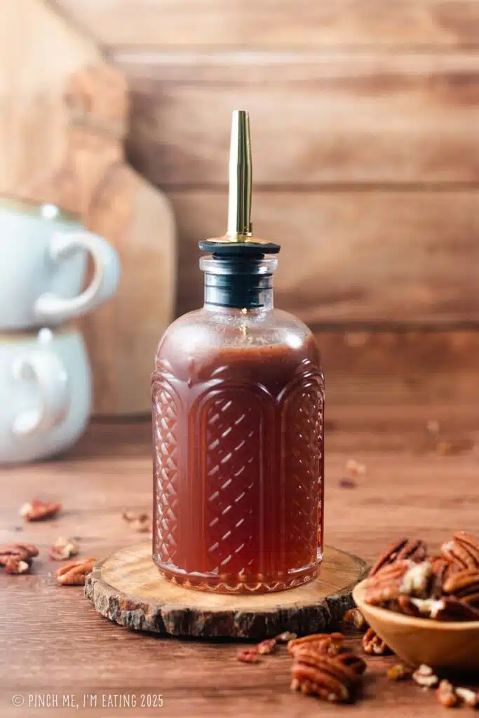 Pecan syrup for coffee in a glass pour bottle.