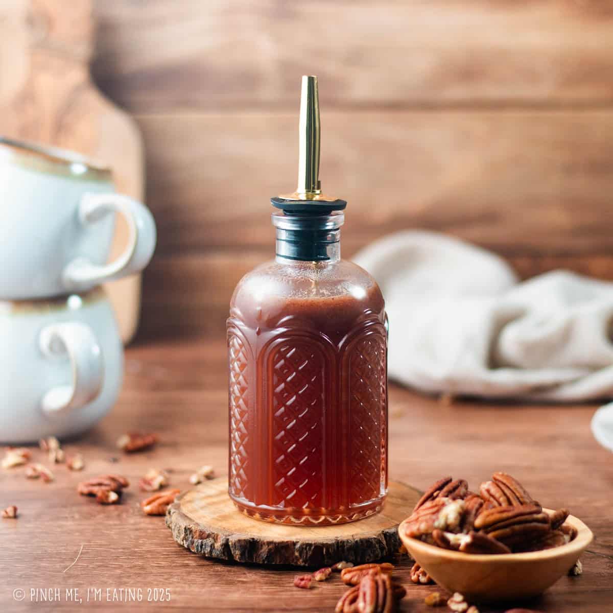 Pecan coffee syrup in a glass pour bottle.