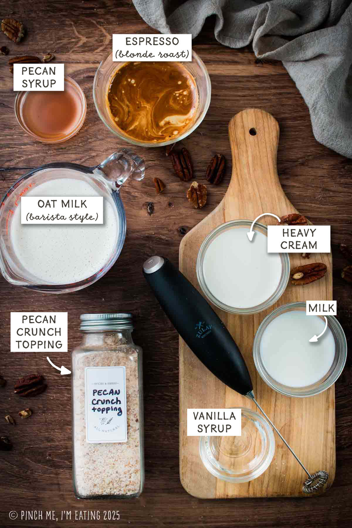 Labeled ingredient photo including espresso, oat milk, pecan syrup, cream, milk, vanilla syrup, and pecan crunch topping.