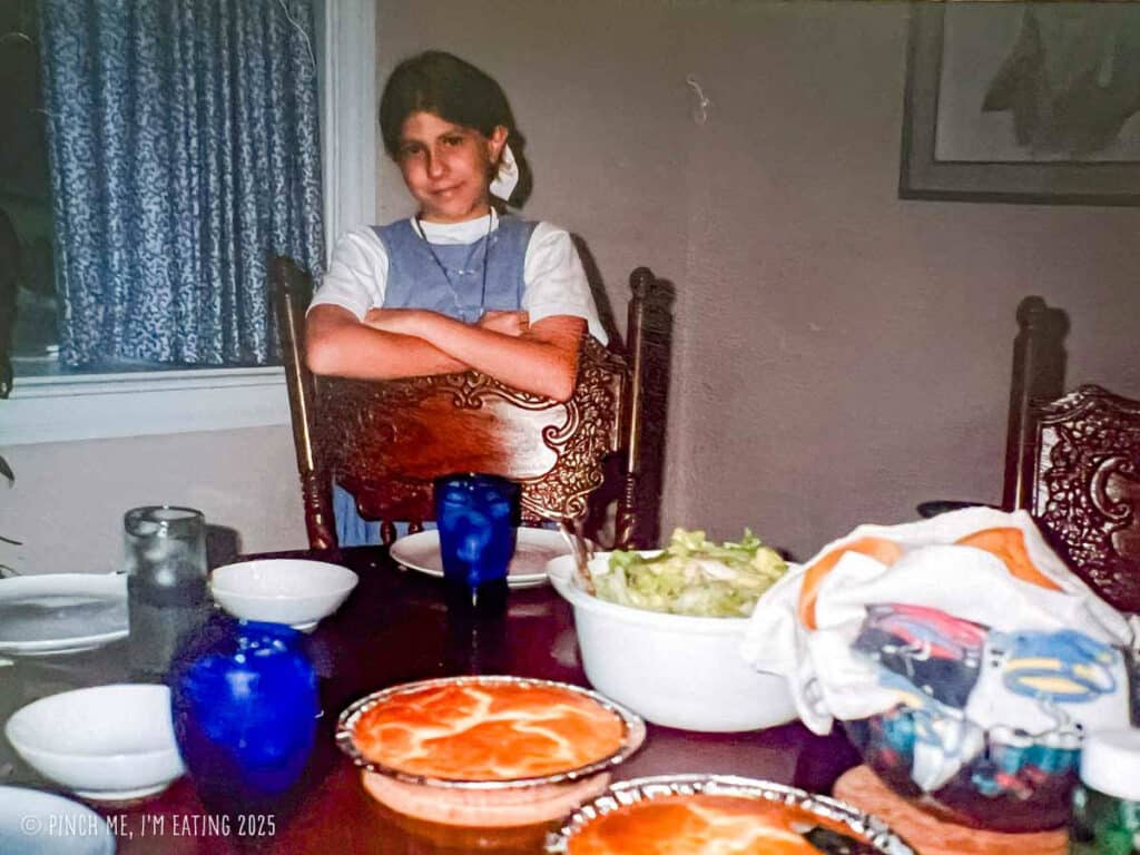 Caroline standing behind a dinner table with salad and pot pies.