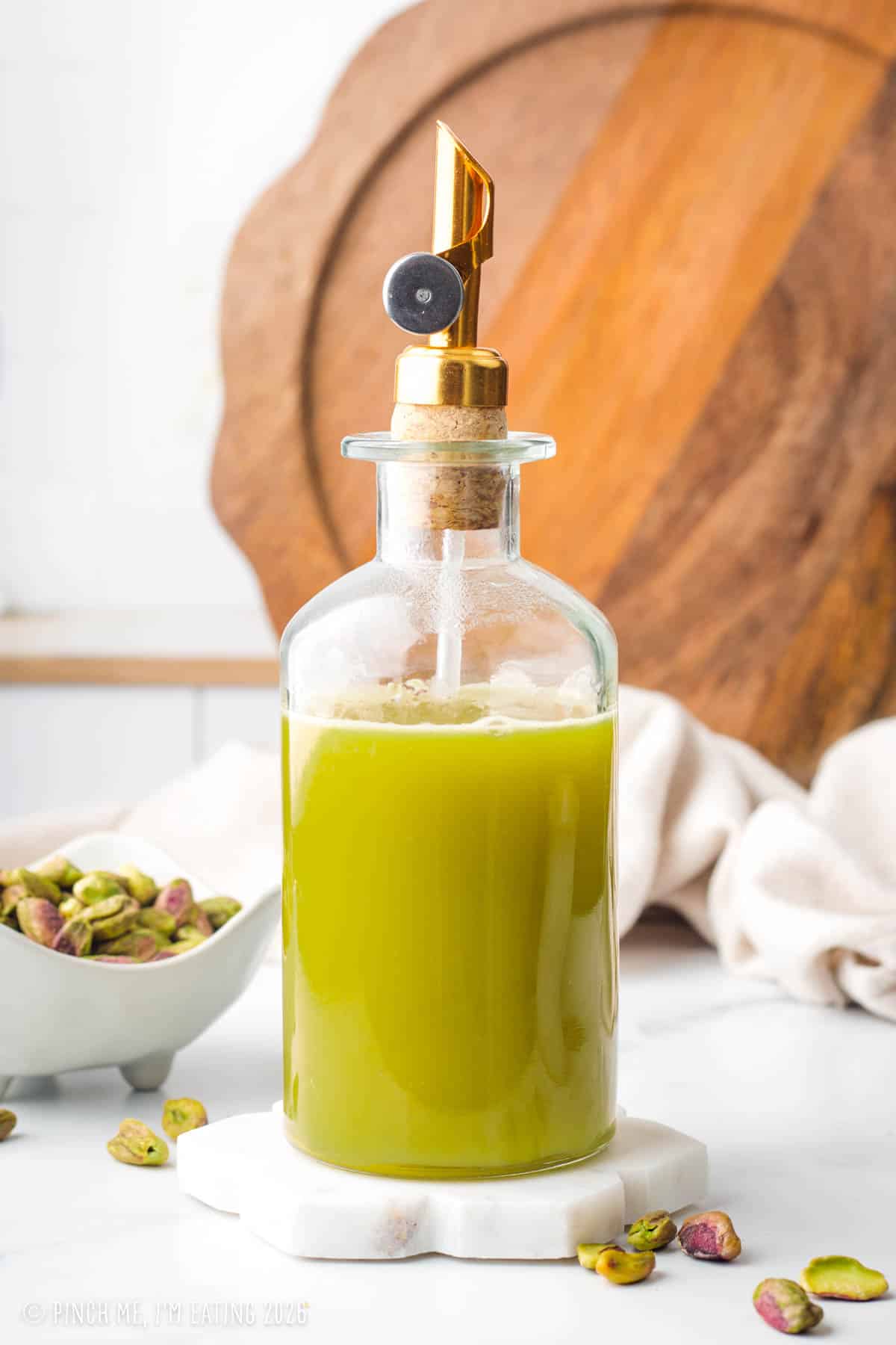 Homemade pistachio syrup for coffee in a glass bottle.