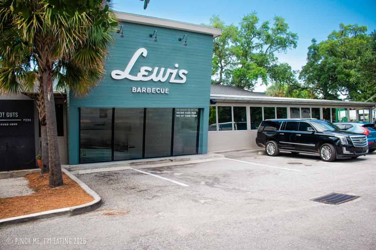 The exterior storefront of Lewis Barbecue in Charleston, SC, featuring the restaurant's white script logo on a blue building.